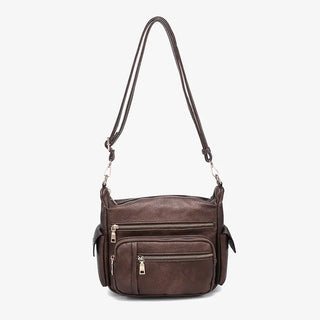 Brown leather handbag with multiple zippers on a white background