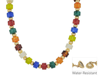 A multicolor beaded necklace with faceted glass-like cube beads in red, blue, green, orange, yellow, and white, separated by small gold spacer beads. A small inset at the bottom right shows a gold heart-shaped charm and the text 'Water-Resistant' on a white background.