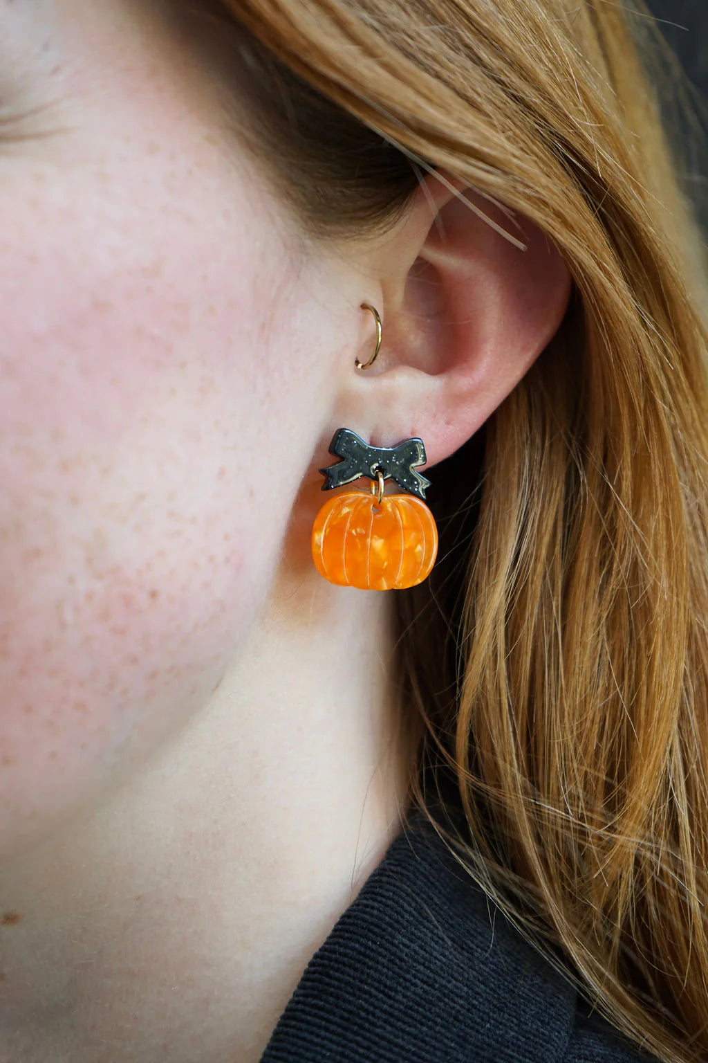 Orange pumpkin dangle earrings with a black bow
