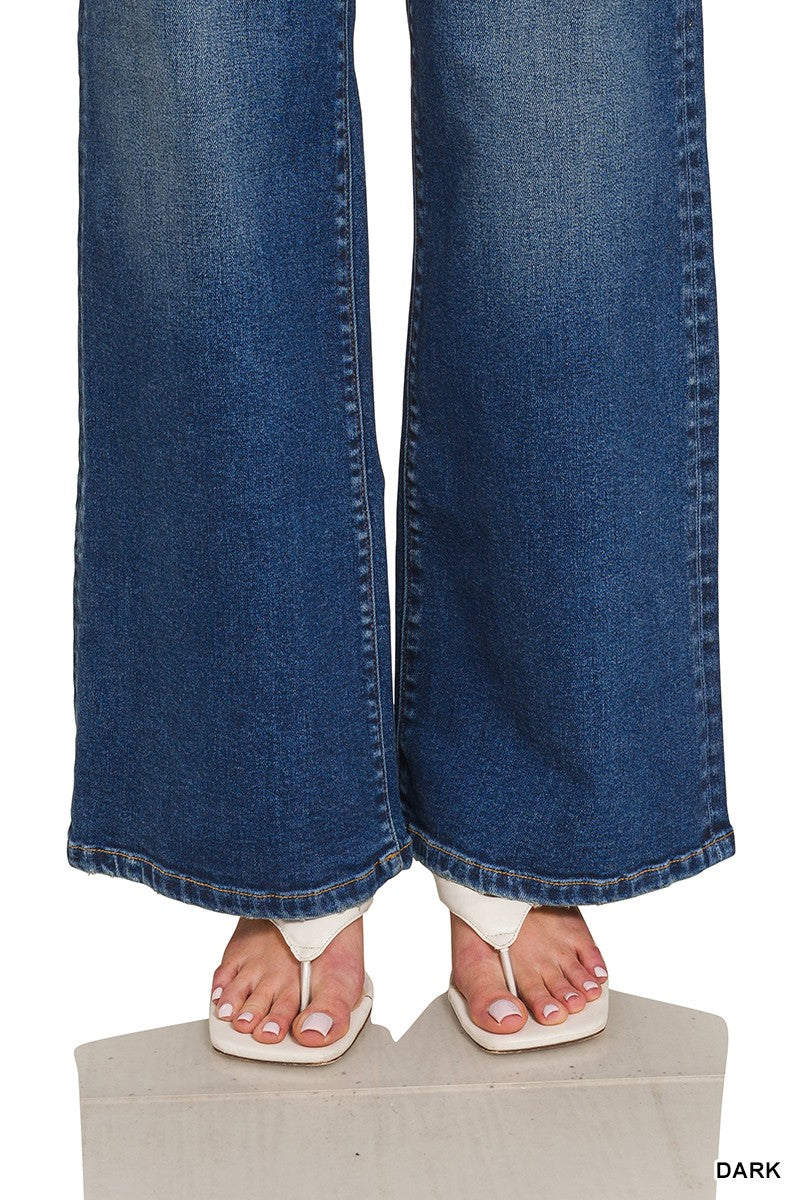 Dark blue flared jeans on a white background