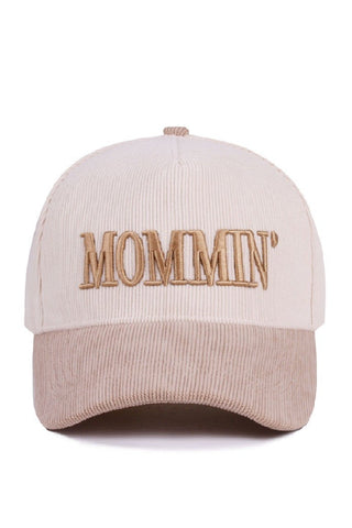 Beige cap with 'MOMMIN' text on a white background