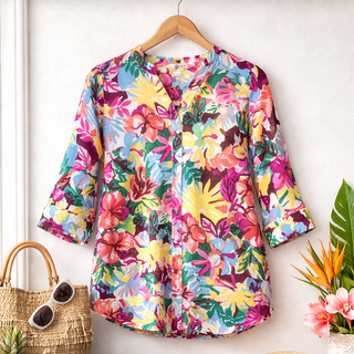 Colorful floral dress on a hanger with a white background