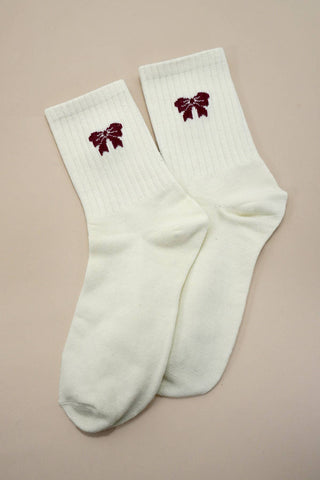White socks with red floral designs on a beige background