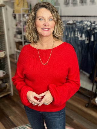 Woman wearing a red sweater in a store setting