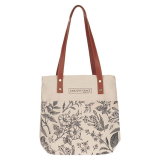Tote bag with floral pattern and brown straps on a white background