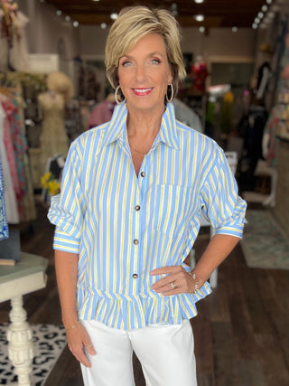 Woman wearing a blue and yellow striped shirt in a store setting