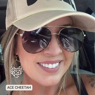 Person wearing a beige cap and sunglasses with 'ACE CHEETAH' branding.