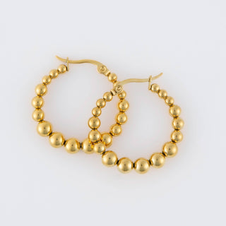 Gold hoop earrings with bead detailing on a white background