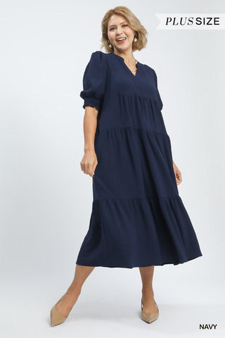 Woman wearing a navy blue dress on a white background with 'Plus Size' text.