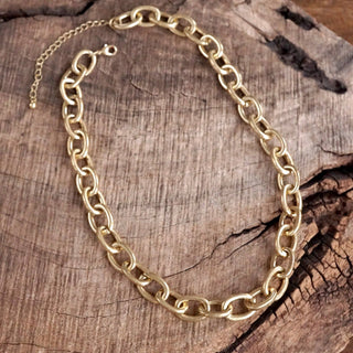 Gold chain necklace on a wooden surface