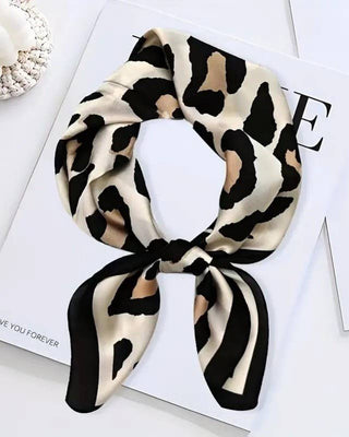 Leopard print headscarf on a white surface with decorative elements