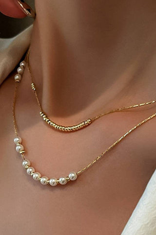 Gold necklace with pearls worn by a person