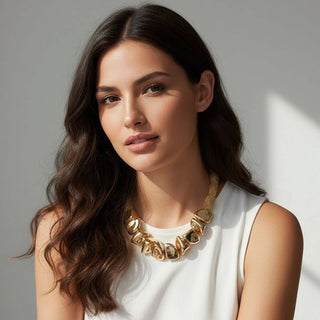 Woman wearing a gold necklace against a neutral background