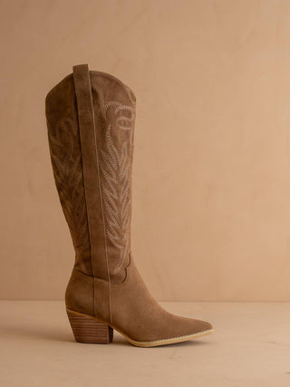 Brown cowboy boot with intricate design on a beige background