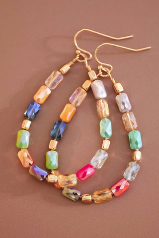 Colorful beaded earrings on a brown background