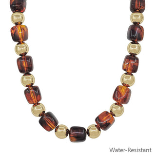 Necklace with brown and gold beads on a white background