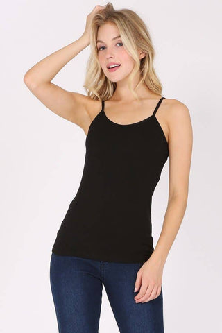 Woman wearing a black tank top and blue jeans on a white background