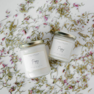Two candles labeled 'Poppy' on a floral fabric background