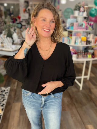 Woman wearing a black top and blue jeans in a store setting