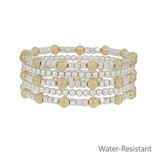 Set of beaded bracelets with gold and silver tones on a white background