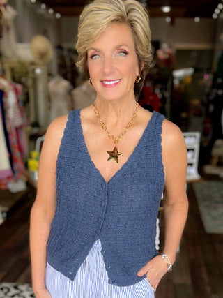 Woman wearing a blue vest and light blue shorts in a store setting