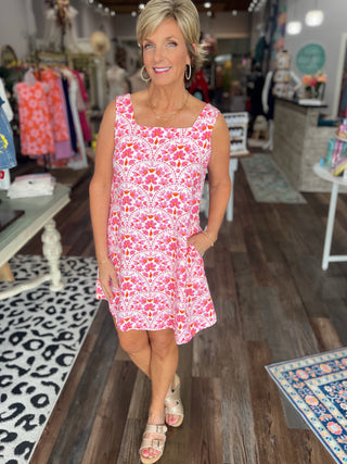 Woman wearing a pink floral dress in a store setting