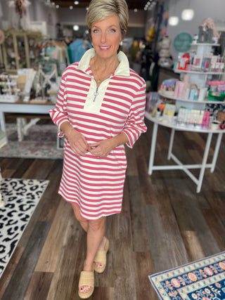 Woman wearing a pink and white striped dress in a store setting