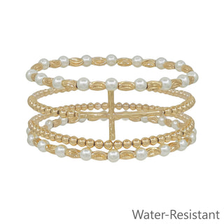 Set of gold and pearl beaded bracelets on a white background