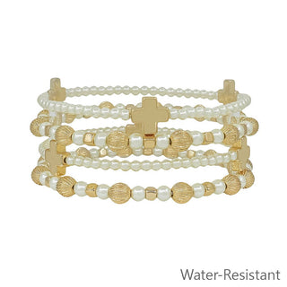 A stack of four beaded bracelets featuring white faux pearls, textured gold beads, and gold cross charms, displayed on a clean white background with a 'Water-Resistant' text overlay in the bottom right corner.