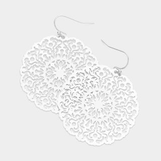 White lace-style earrings on a light gray background