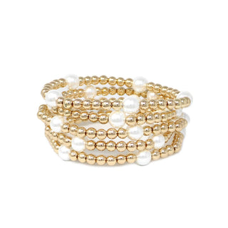 Set of gold and white beaded bracelets on a white background