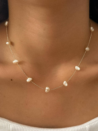 Pearl necklace on a person's neck with a blurred background