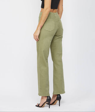 A woman modeling a pair of high-waisted, straight-leg olive green pants with a black sleeveless crop top and black high-heeled sandals, shown from a side-back angle against a light gray studio background.