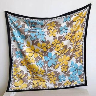 Floral patterned fabric square with yellow, blue, and brown flowers on a white background