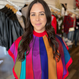 Woman wearing a multicolor striped drape for color analysis inside a boutique.