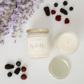 Candle jar labeled 'My Oh My' with berries and flowers on a white background