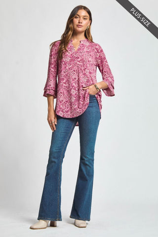 Woman wearing a pink floral blouse and blue jeans on a white background