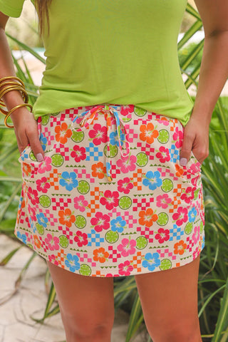Person wearing a colorful floral skirt with a green top against a natural background