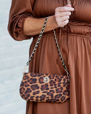 leopard print handbag held by lady in brown dress