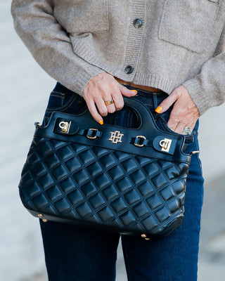 Black Handbag/Clutch held by woman in jeans 
